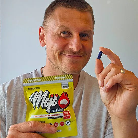 A customer holding a MOJO™ LIONS MIND capsule and pack